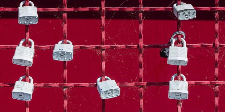 a fence with locks attached, outdoors, red
