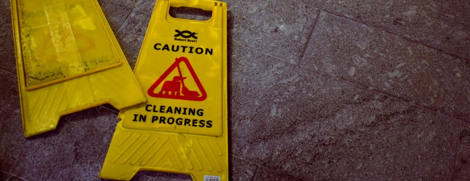 caution cleaning signs laying on the ground flat