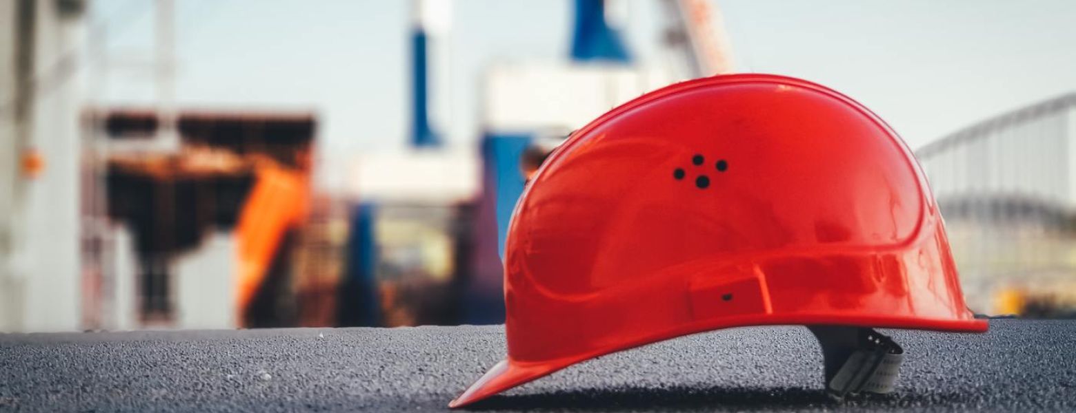 red safety helmet sitting on the ground, outdoors