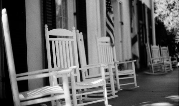 white rocking chairs in front of building, outdoors