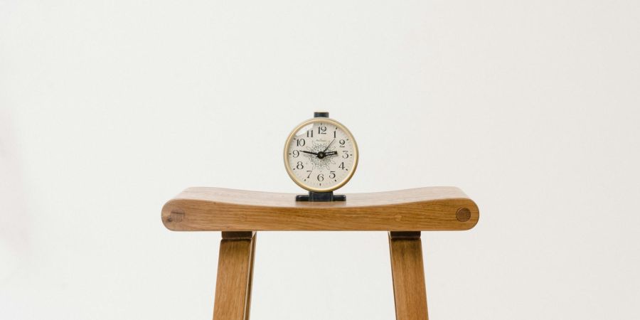 a clock on a little table indoors