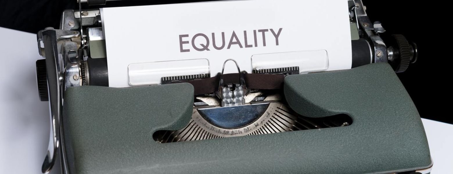 old typewriter with a page that says equality, indoors