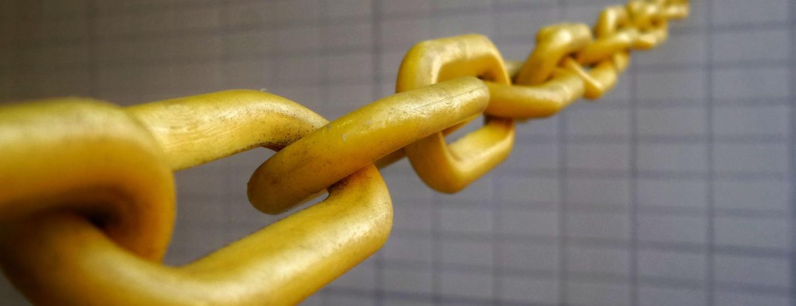 golden chain stretched out from brick like wall