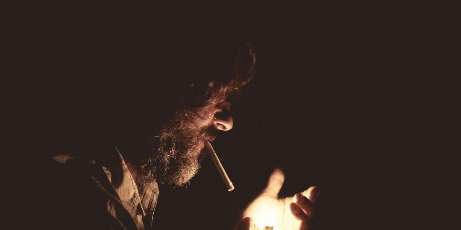 man smoking, in the dark