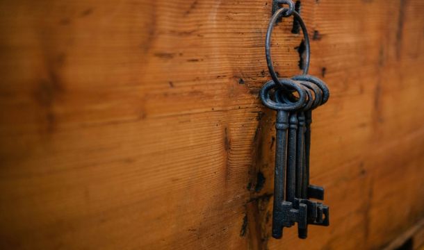 old fashio keys, hanging on a ring, attached to a wood board