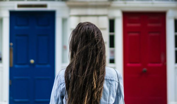 woman outdoors, two doors, red and blue choice