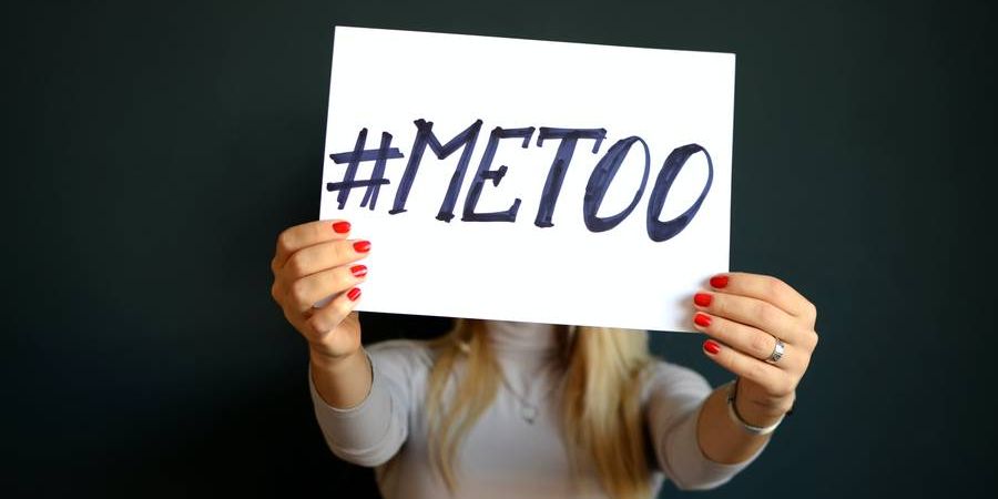 #metoo sign being held by a woman indoors