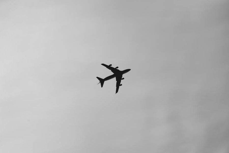 airplane in the sky, outdoors, black and white