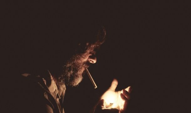 man smoking, in the dark